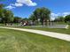 Community playground with slides, swings, and climbing structures surrounded by green grass and mature trees at 13358 Briarwood Dr, Broomfield, CO 80020