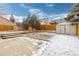 A spacious backyard features two sheds, a small patio and a partially snow-covered lawn at 2888 S Fundy St, Aurora, CO 80013