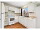 Cozy kitchen with white cabinets, wood floor, and bright window at 2888 S Fundy St, Aurora, CO 80013