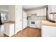 Well-lit kitchen with white appliances, ample counter space, and hardwood floors at 2888 S Fundy St, Aurora, CO 80013