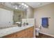 Well-lit bathroom featuring a granite vanity top, framed mirror, and a shower with glass door at 8617 Gold Peak Dr # D, Highlands Ranch, CO 80130