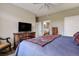 Relaxing bedroom with a cozy bed, wooden dresser with television and access to the ensuite bathroom at 8617 Gold Peak Dr # D, Highlands Ranch, CO 80130