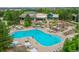 An aerial view of a community pool surrounded by lounge chairs, umbrellas and green landscaping at 8617 Gold Peak Dr # D, Highlands Ranch, CO 80130