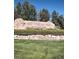 A stone sign with 'Palomino Park' and horse emblems surrounded by stone wall and lush greenery at 8617 Gold Peak Dr # D, Highlands Ranch, CO 80130