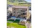 Landscaped backyard with putting green, patio, fire pit, and terraced garden beds with mountain views at 2125 S Orion St, Lakewood, CO 80228
