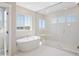 Elegant bathroom showcasing a soaking tub next to a spacious glass-enclosed shower with mountain views at 2125 S Orion St, Lakewood, CO 80228