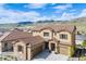A view of a modern home with dual garage doors, stone accents, and lush landscaping at 2125 S Orion St, Lakewood, CO 80228