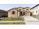 Charming two-story home with a stone facade, manicured lawn, and a welcoming front entrance at 2125 S Orion St, Lakewood, CO 80228