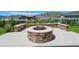 A stone outdoor firepit situated in a manicured backyard at 2125 S Orion St, Lakewood, CO 80228