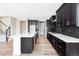 Modern kitchen boasts an island, sleek countertops, stainless appliances, and dark cabinets at 2125 S Orion St, Lakewood, CO 80228