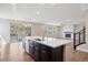Modern kitchen with island, stainless steel appliances, quartz counters, and an open floor plan leading to outdoor deck at 2125 S Orion St, Lakewood, CO 80228