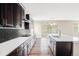 Modern kitchen featuring dark cabinets, quartz countertops and a central island with a view at 2125 S Orion St, Lakewood, CO 80228