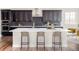 Contemporary kitchen island features pendant lighting, bar seating, and dark cabinetry with white countertop at 2125 S Orion St, Lakewood, CO 80228