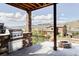 Inviting outdoor kitchen with stone accents, a built-in grill, and cozy fire pit at 2125 S Orion St, Lakewood, CO 80228