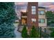 Beautiful modern home with a brick facade, a metal balcony, and well-maintained landscaping at dusk at 402 Garfield St, Denver, CO 80206