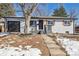 Charming home with updated exterior, landscaped front yard, and attached garage at 6894 Nelson St, Arvada, CO 80004