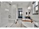 Bright bathroom showcases a modern glass-enclosed shower, standalone tub, and sleek fixtures at 21345 E 59Th Dr, Aurora, CO 80019