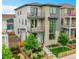 Contemporary three-story home featuring a stone facade, multiple balconies, and a well-manicured yard with a wooden fence at 21345 E 59Th Dr, Aurora, CO 80019