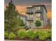 Beautiful modern three-story home with stone accents and balconies, complemented by professional landscaping and a charming picket fence at 21345 E 59Th Dr, Aurora, CO 80019
