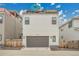 Modern two story home featuring a gray garage door and white siding at 21345 E 59Th Dr, Aurora, CO 80019