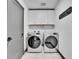 Functional laundry room with modern washer and dryer, white cabinets, and modern finishes at 21345 E 59Th Dr, Aurora, CO 80019