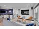 Open concept living room with a wet bar, modern furniture, and a large television at 21345 E 59Th Dr, Aurora, CO 80019