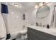 Well-lit bathroom with a vanity featuring marble countertops, a shower with white subway tile, and modern fixtures at 3141 S Tamarac Dr # 202E, Denver, CO 80231