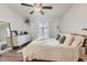 Bright bedroom featuring a ceiling fan, white dresser, and a cozy bed near a sliding glass door at 3141 S Tamarac Dr # 202E, Denver, CO 80231
