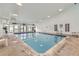 Indoor pool area with clear blue water, ample lighting, and chairs for relaxation at 3141 S Tamarac Dr # 202E, Denver, CO 80231