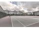 Outdoor tennis courts surrounded by buildings with balconies under a partly cloudy sky at 3141 S Tamarac Dr # 202E, Denver, CO 80231