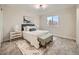 A bedroom with a large window, neutral walls, and a geometric patterned rug over light brown carpeting at 4591 S Fairplay St, Aurora, CO 80015