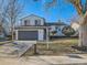 Two-story home featuring a gray garage door, well-maintained lawn, and manicured landscaping at 4591 S Fairplay St, Aurora, CO 80015