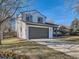 A sunny view of a home with a gray garage door, a well-kept lawn, and mature trees at 4591 S Fairplay St, Aurora, CO 80015