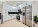 Modern kitchen with stainless steel appliances, white cabinetry, black subway tile, and light wood-look flooring at 4591 S Fairplay St, Aurora, CO 80015