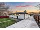 Well-maintained backyard with a concrete patio and walkway, green grass, and a privacy fence at 6142 Dudley Ct, Arvada, CO 80004