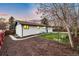 Backyard features include a mulched area, green grass, and a small concrete patio and walkway at 6142 Dudley Ct, Arvada, CO 80004