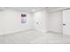 Clean basement with neutral carpet, featuring a window and access to another room at 6142 Dudley Ct, Arvada, CO 80004