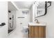 Modern bathroom with sleek vanity, a shower featuring white tile, and stylish fixtures at 6142 Dudley Ct, Arvada, CO 80004