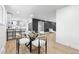 Open-concept dining area connected to a modern kitchen and living room with bar stool seating at the breakfast bar at 6142 Dudley Ct, Arvada, CO 80004