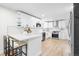 Bright kitchen with white cabinets, modern appliances, quartz countertops, and hardwood floors at 6142 Dudley Ct, Arvada, CO 80004