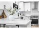 Bright modern kitchen with white countertops, white cabinets and stainless steel appliances at 6142 Dudley Ct, Arvada, CO 80004