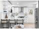 Open kitchen with modern white cabinets, updated appliances, and hardwood floors at 6142 Dudley Ct, Arvada, CO 80004