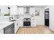 Updated kitchen with stainless steel appliances, white cabinets, and hardwood floors at 6142 Dudley Ct, Arvada, CO 80004