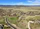 An aerial view showcases a sprawling, grassy home site with a scenic vista at 3891 Windchant Cir, Castle Rock, CO 80104