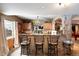 Open bar with granite counter, barstool seating, stone archway, and window views at 3891 Windchant Cir, Castle Rock, CO 80104