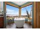 Modern bathroom features a stand-alone tub by a window overlooking mountain scenery at 3891 Windchant Cir, Castle Rock, CO 80104