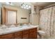 Well-lit bathroom with a double vanity, floral shower curtain, and tiled countertop at 3891 Windchant Cir, Castle Rock, CO 80104