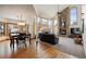 Open floor plan: dining area adjacent to a living room with a stone fireplace and large windows at 3891 Windchant Cir, Castle Rock, CO 80104