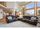 Spacious living room with a comfortable leather sofa and large windows overlooking a winter landscape at 3891 Windchant Cir, Castle Rock, CO 80104