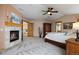 Main bedroom features stone fireplace, carpet, wooden trim, ceiling fan, and cozy decorations at 3891 Windchant Cir, Castle Rock, CO 80104